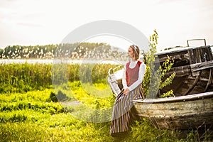 Latvian woman in traditional clothing on old boat.