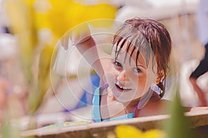 Laugh is the biggest indicator of a kidâ€™s happiness. Cute little child girl having fun in swimming pool. Kid playing outdoors.