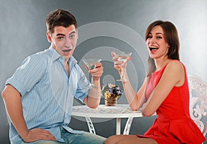 Laugh and drunk couple with glasses of champagne at table