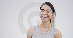 Laugh, face and happy woman in studio with funny, joke or crazy news on grey background. Comic, portrait and goofy