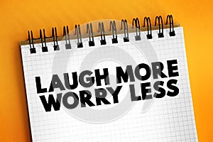 Laugh More Worry Less text on notepad, concept background