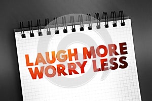 Laugh More Worry Less text quote on notepad, concept background