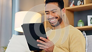 Laugh, relax and asian man with a tablet a sofa for social media, chat or streaming at home. Digital, app and Japanese