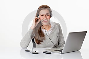 Laughing 20s professional with headset and computer in white office