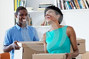 Laughing african american couple moving to new house