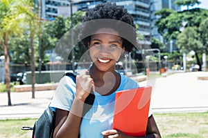 Laughing african american female student on campus of university