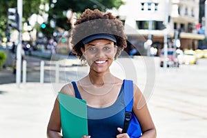 Laughing african american female student outdoor in city