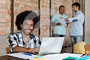 Laughing african american hipster software developer at computer