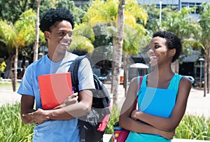Laughing african american male and female student on campus of u
