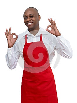 Laughing african american waiter with red apron