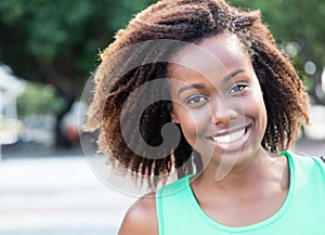 Laughing african american woman in a green shirt outdoor