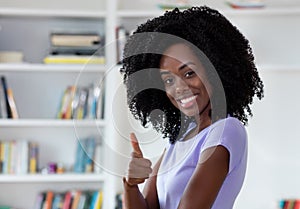 Laughing african american woman showing thumb up