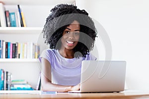 Laughing african american woman working at computer