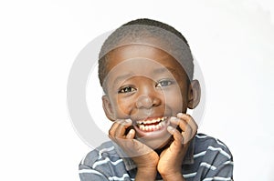 Laughing African child holds his head whilst thinking Africa ethnicity black boy