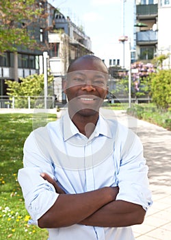 Laughing african man outside with crossed arms