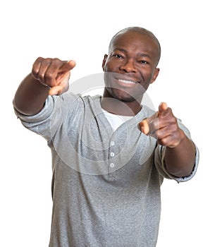 Laughing african man pointing with two fingers at camera