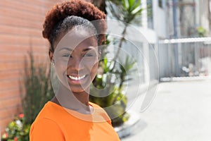 Laughing african woman in a orange shirt