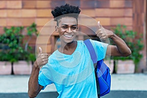 Laughing afro american freshman showing both thumbs up photo