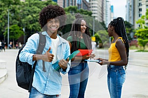 Laughing afro american male student with group of young adults