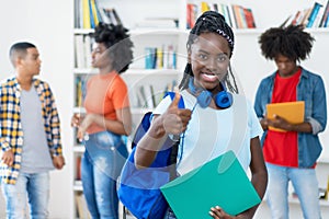 Laughing afro american young adult with dreads and group of students