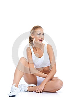 Laughing athletic woman sitting on the floor