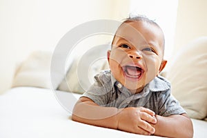 Laughing Baby Boy Lying On Tummy At Home