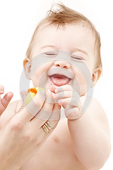 Laughing baby boy in mother hands with rubber duck