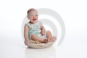 Laughing Baby Boy Sitting in a Rustic Bowl