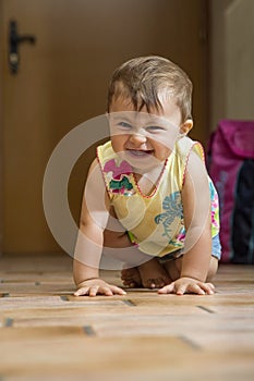 Laughing baby girl crawling on floor