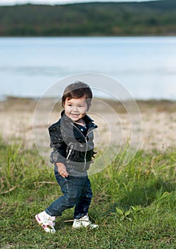 Laughing baby girl crouching in the grass