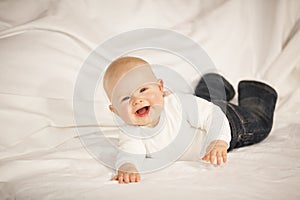 Laughing baby girl lying on a couch