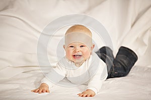 Laughing baby girl lying on a couch