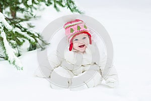 Laughing baby girl sitting under Christmas tree