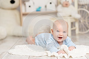 laughing baby lies at home in the children\'s room with toys  development concept and games