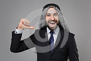 Laughing bearded arabian muslim businessman in keffiyeh kafiya ring igal agal classic black suit tie isolated on gray