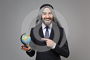 Laughing bearded arabian muslim businessman in keffiyeh kafiya ring igal agal classic suit isolated on gray background