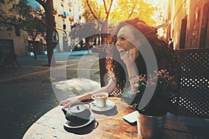 Laughing beautiful curly girl in cafe