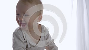 Laughing beautiful toddler having fun riding on toy equine indoors