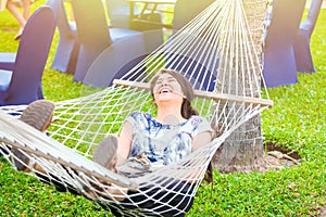 Laughing biracial teen girl relaxing in hammock