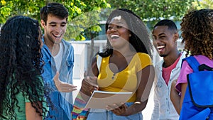 Laughing black female student talking with group of latin american and caucasian young adults