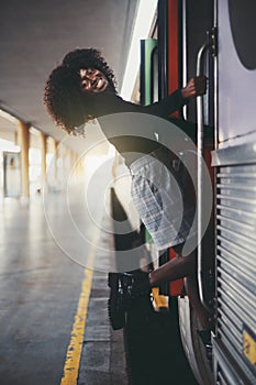 A laughing black girl entering train