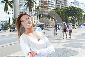 Laughing blonde woman with crossed arms in the city