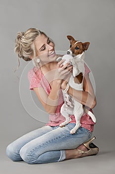 Laughing blonde woman playing with dog