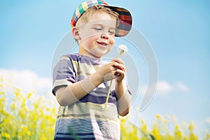 Laughing boy carrying blow-ball in his hands