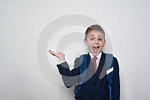 Laughing boy in school uniform on white background holds a hand.. Kid educational. Copy space