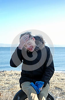 Laughing boy sits in sea