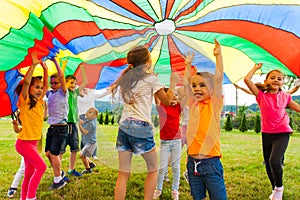 Laughing boy standing hands-up outdoors in the summer photo