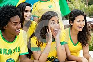 Laughing brazilian soccer fans with flag