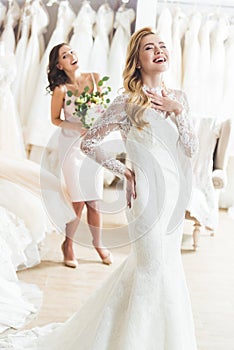 Laughing bride and bridesmaid in wedding