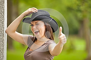 Laughing brunette woman with cowboy hat
